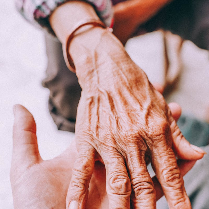 Hands of a caregiver holding a loved one's hands